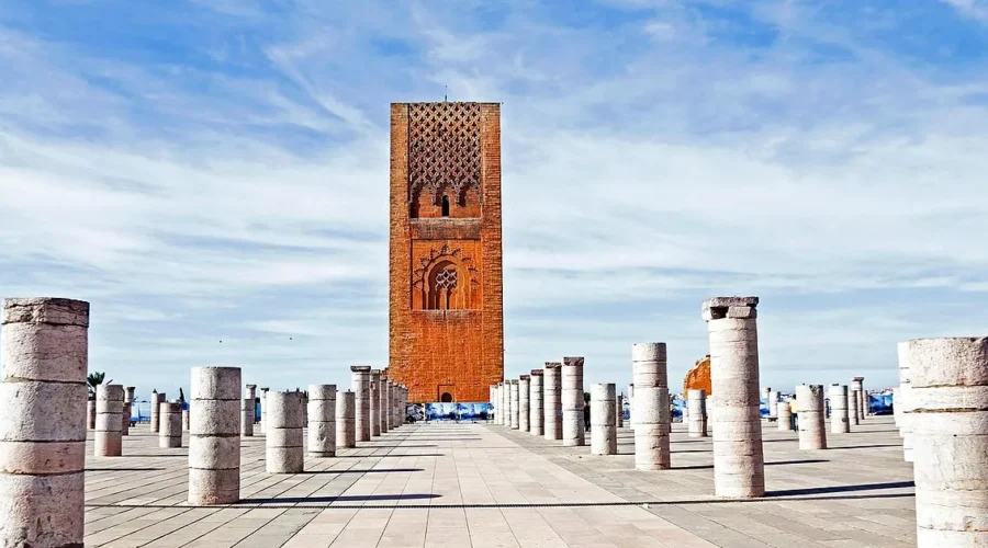 A large red tower with prominent columns in the foreground, showcasing architectural grandeur and vibrant color.