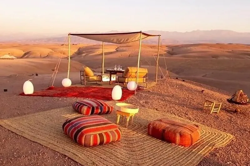  A tent in the desert features a table and chairs, ideal for travelers visiting Morocco in the best month of March.