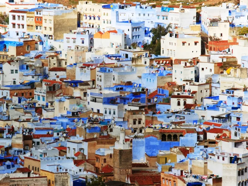  Scenic view of Chefchaouen, Morocco, showcasing its iconic blue buildings and mountainous backdrop, popular with tourists. 