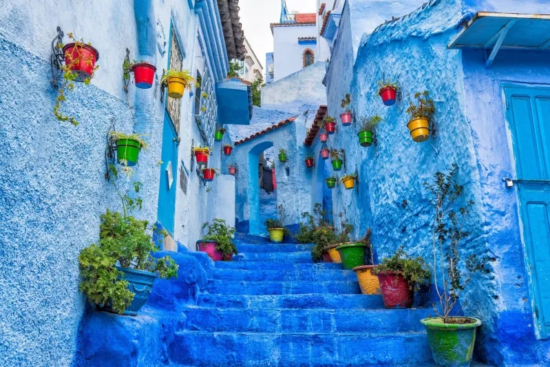 Scenic view of Chefchaouen, Morocco, showcasing its iconic blue buildings and mountainous backdrop, ideal for travel itineraries.