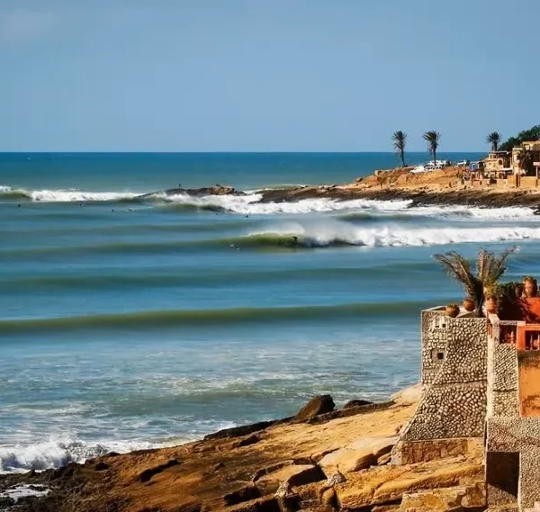A scenic view of the beach and coastal houses in Morocco, ideal for surf travel enthusiasts.