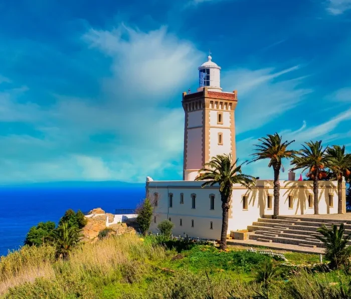 A lighthouse perched on a hill, overlooking the ocean, symbolizing coastal beauty in Morocco.