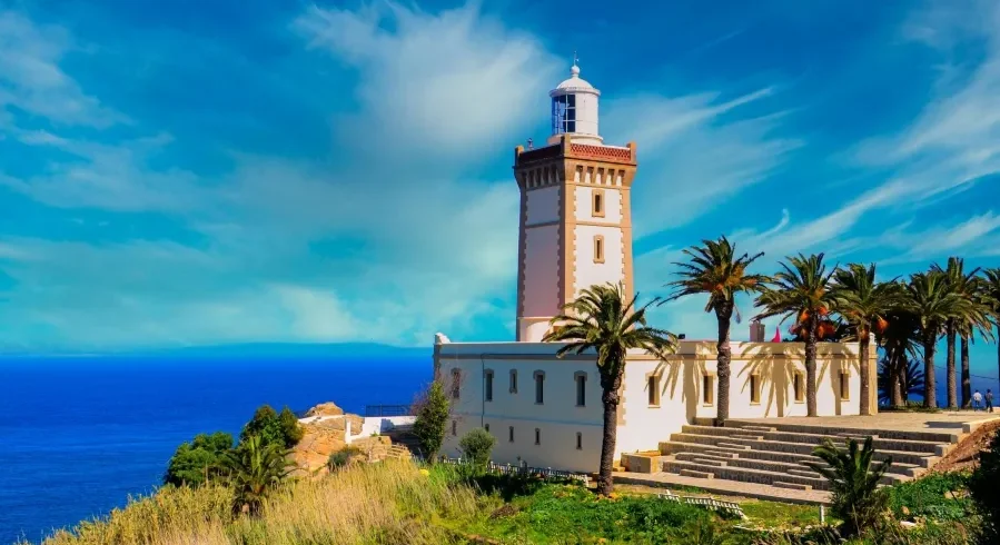 A lighthouse perched on a hill, overlooking the ocean, symbolizing coastal beauty in Morocco.
