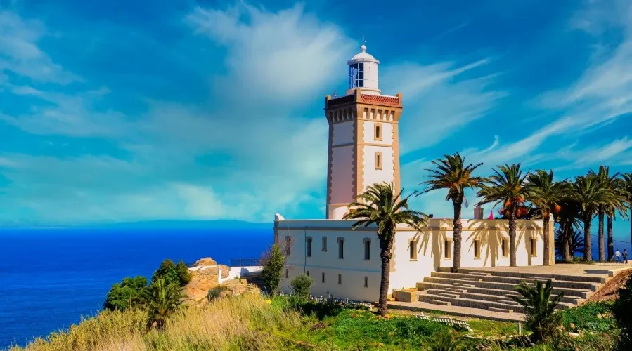 A lighthouse perched on a hill, overlooking the ocean, symbolizing coastal beauty in Morocco.