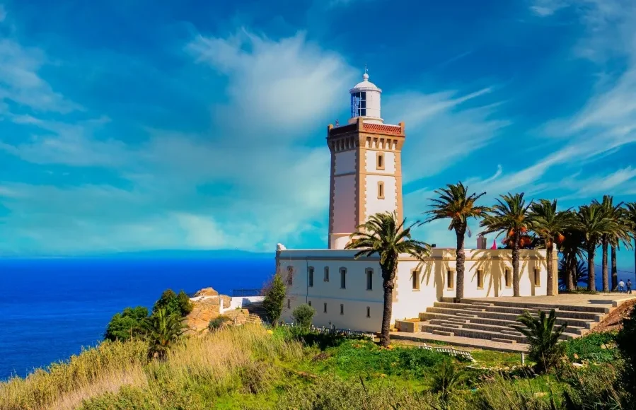 A lighthouse perched on a hill, overlooking the ocean, symbolizing coastal beauty in Morocco.