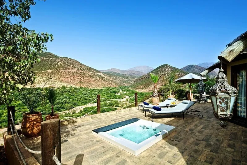 A hot tub on a terrace with a stunning mountain view, featured in Morocco Private Tours. 