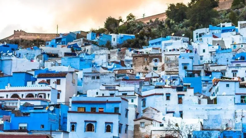Scenic view of Chefchaouen, Morocco, showcasing its iconic blue buildings and mountainous backdrop during a Moroccan holiday.