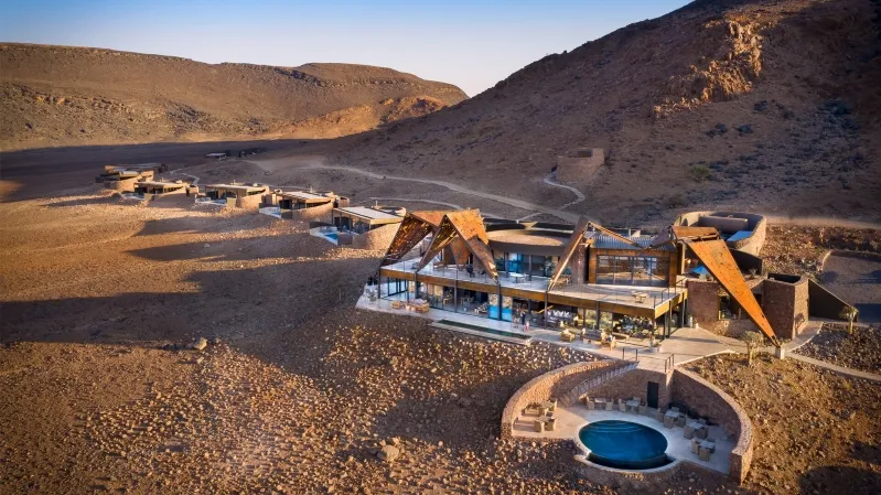  A desert house nestled among mountains, showcasing the rugged beauty of the Moroccan desert landscape.