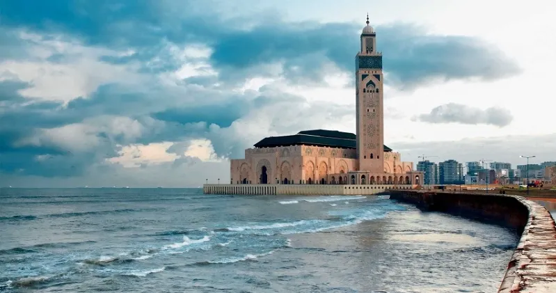  A large mosque overlooks the ocean, showcasing its grandeur against the backdrop of Casablanca's coastal scenery.