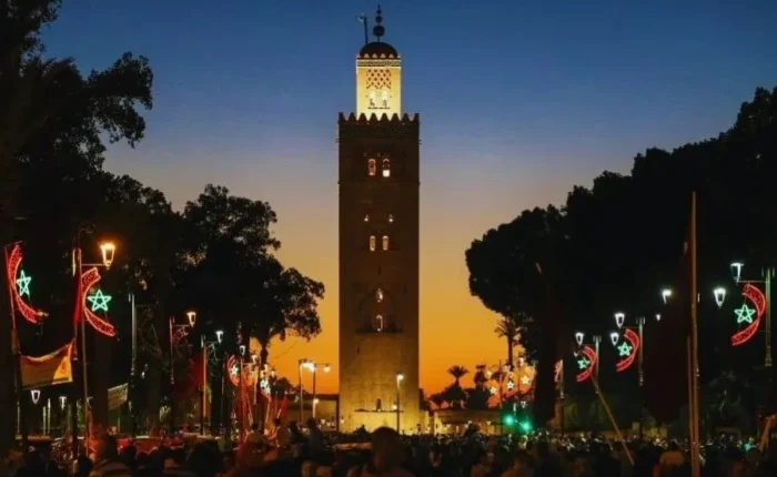 Sunset view of the clock tower in Marrakech, highlighting its silhouette against a vibrant sky for a travel guide.