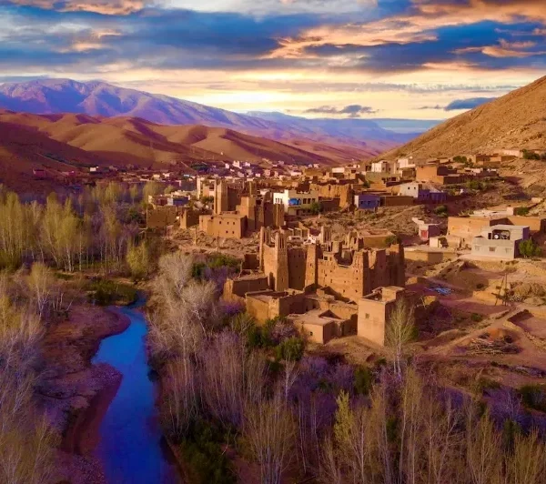 A panoramic view of the village of Atlas in Morocco, showcasing traditional architecture against a mountainous backdrop.