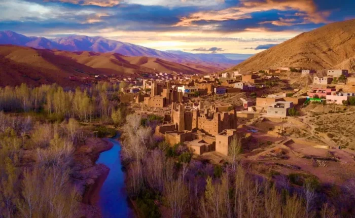 A panoramic view of the village of Atlas in Morocco, showcasing traditional architecture against a mountainous backdrop.