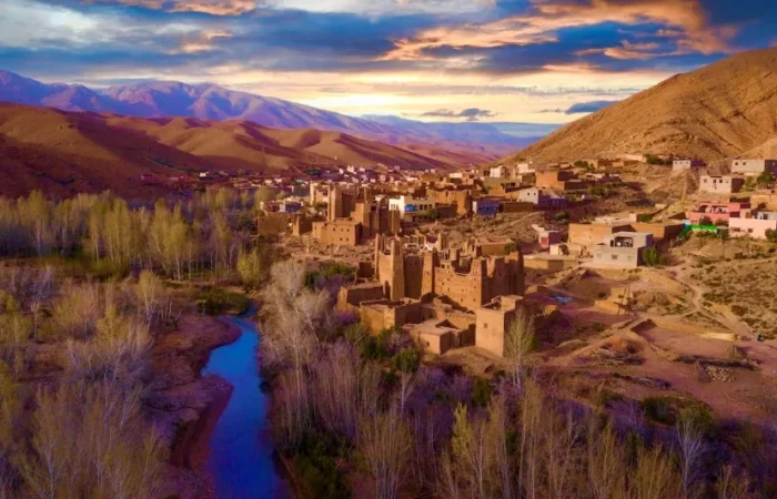 A panoramic view of the village of Atlas in Morocco, showcasing traditional architecture against a mountainous backdrop.