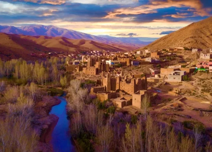 A panoramic view of the village of Atlas in Morocco, showcasing traditional architecture against a mountainous backdrop.