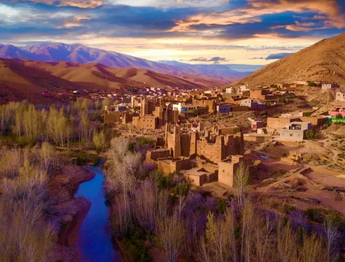 A panoramic view of the village of Atlas in Morocco, showcasing traditional architecture against a mountainous backdrop.
