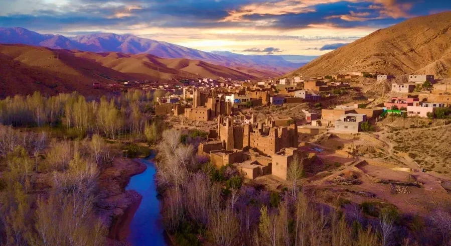 A panoramic view of the village of Atlas in Morocco, showcasing traditional architecture against a mountainous backdrop.