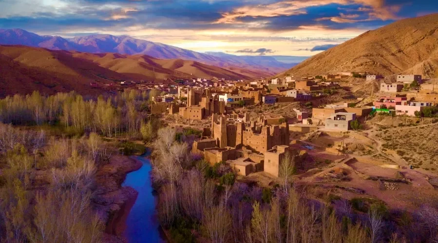 A panoramic view of the village of Atlas in Morocco, showcasing traditional architecture against a mountainous backdrop.