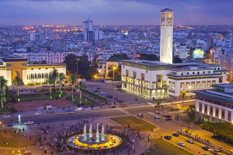 Casablanca skyline at dusk, showcasing illuminated buildings and the vibrant atmosphere of the city.