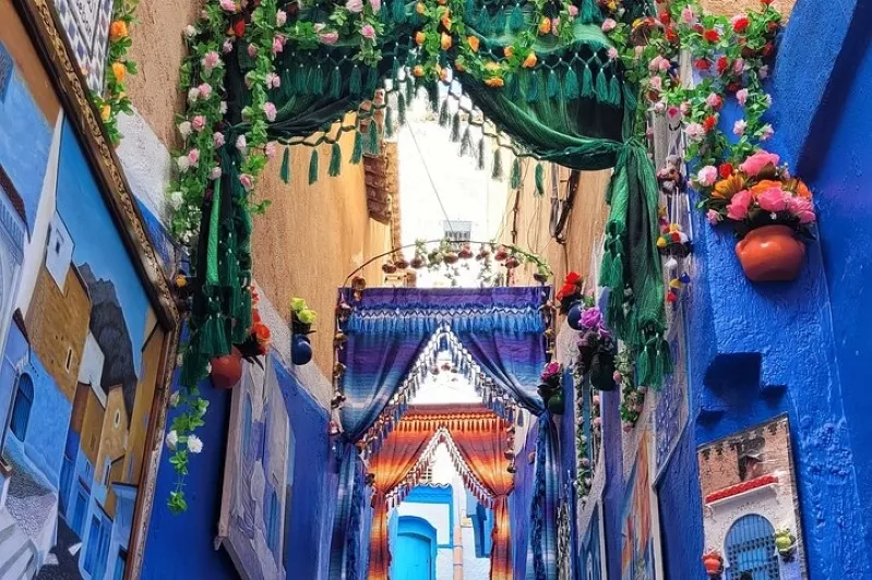 Scenic view of Chefchaouen, Morocco, showcasing its iconic blue buildings and mountainous backdrop, featured in a Marrakech travel guide.