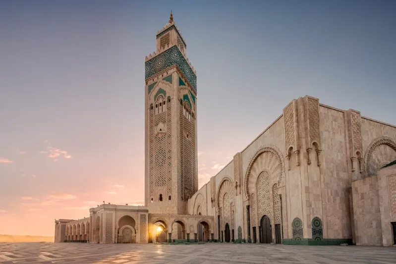 The Hassan II Mosque in Casablanca, Morocco, showcasing its stunning architecture against a clear blue sky.
