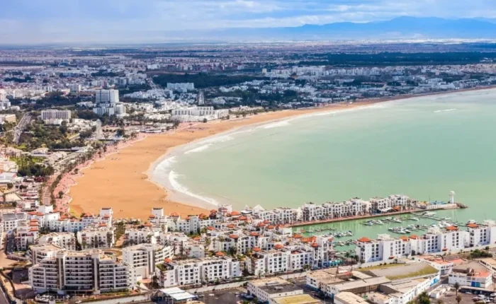 Aerial view of Marrakech, Morocco, showcasing its vibrant architecture and layout, with a suggestion to visit Agadir.