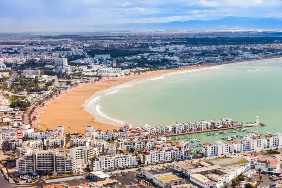 Aerial view of Marrakech, Morocco, showcasing its vibrant architecture and layout, with a suggestion to visit Agadir.