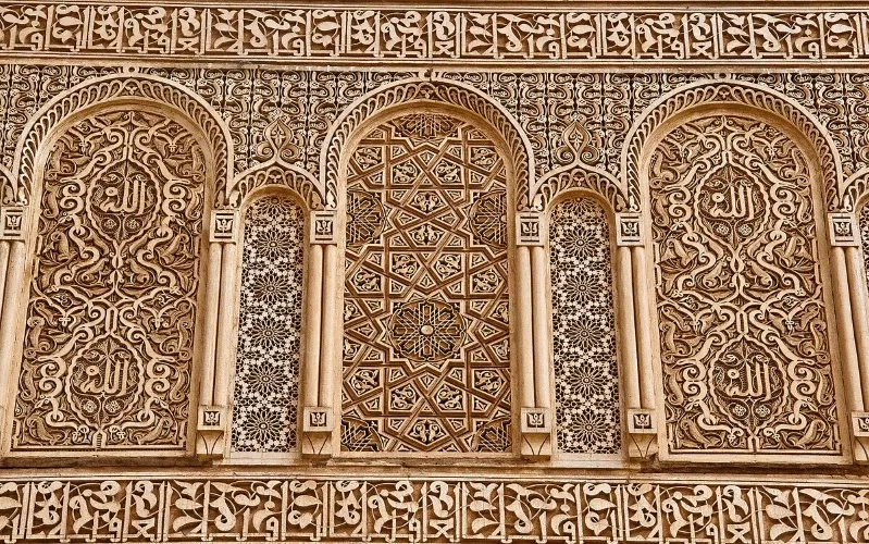 Intricate carvings adorn the exterior of a building, showcasing Morocco's rich cultural heritage on a Morocco cultural tours.