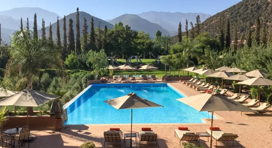 A serene pool area featuring lounge chairs and umbrellas, ideal for relaxation during luxury tours in Morocco.