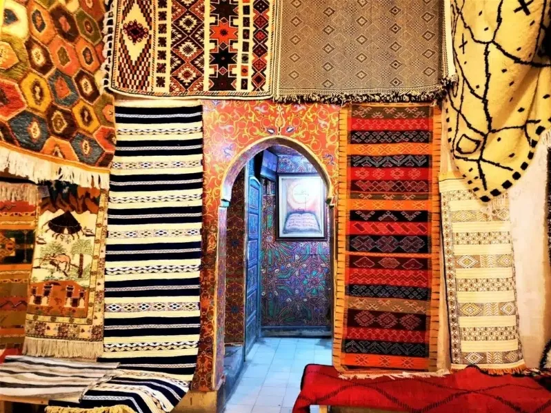 A luxurious room featuring an array of colorful rugs spread across the floor, showcasing Moroccan design elements.