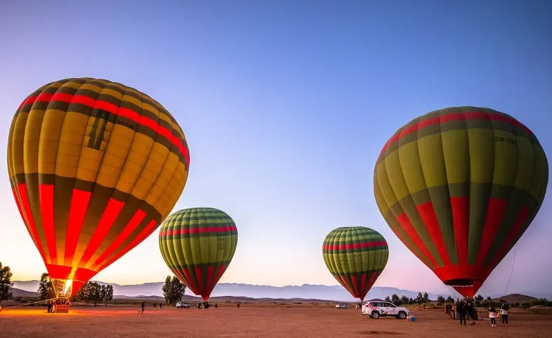 A picturesque scene of hot air balloon ride Morocco in the Moroccan desert at sunset, highlighting the beauty of the evening sky.