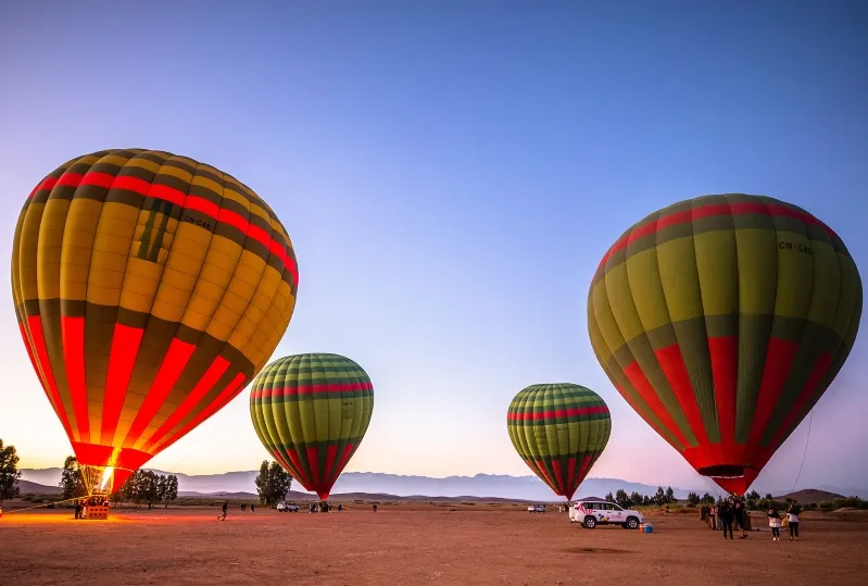 A picturesque scene of hot air balloon ride Morocco in the Moroccan desert at sunset, highlighting the beauty of the evening sky.