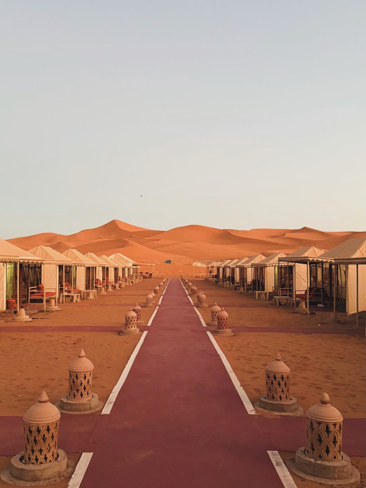 Interior of a spacious luxury tent suite in a Morocco desert luxury camp with a king bed and Moroccan furnishings