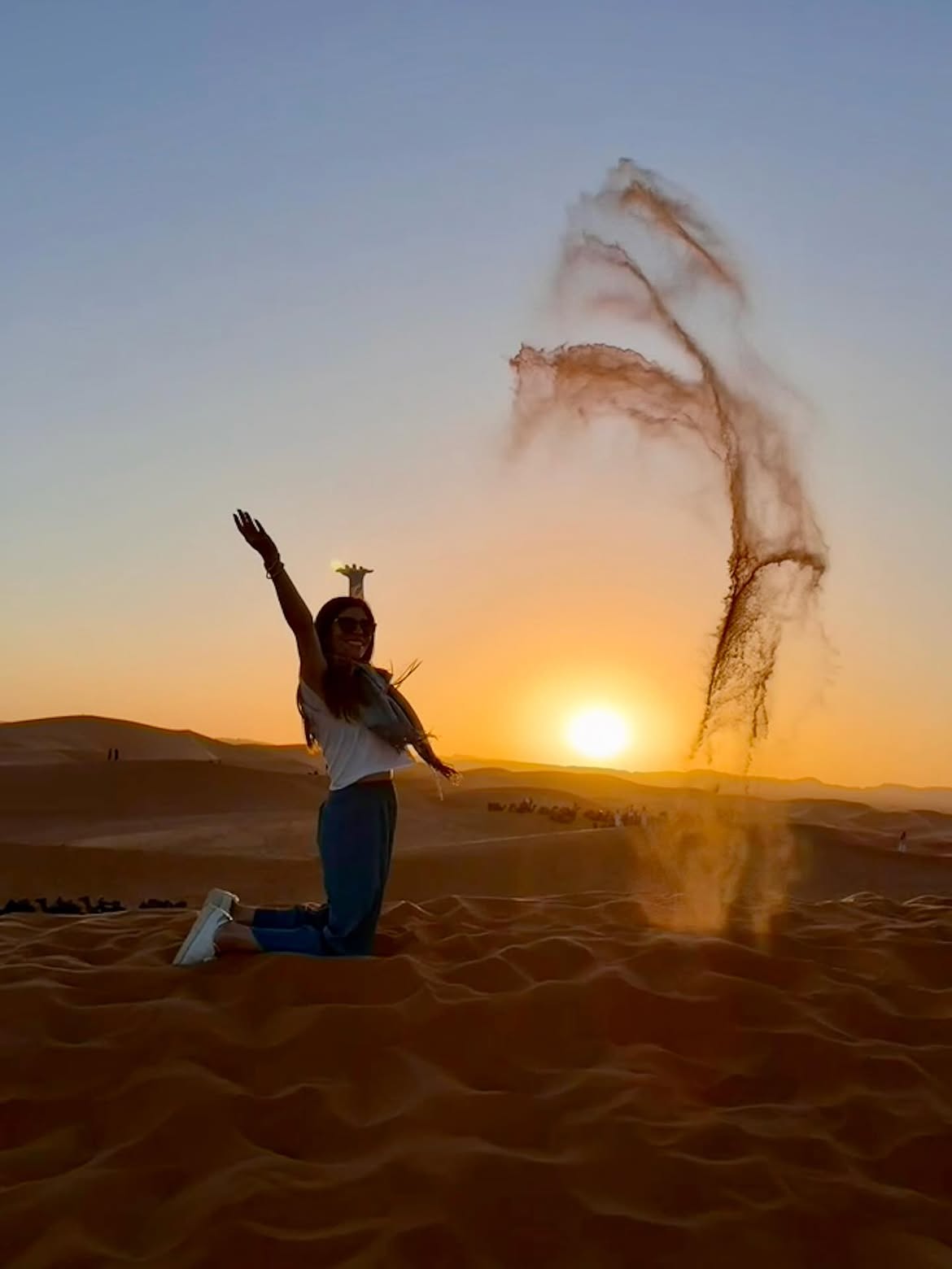 Sunrise casting golden light over the dunes of Merzouga near a Morocco desert luxury camp