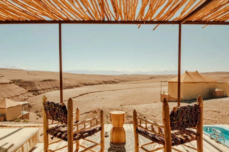 View from the luxury pool at Merzouga camp, showcasing the serene desert landscape and distant sand dunes.
