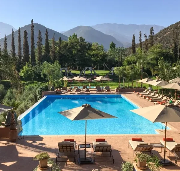 A serene pool area featuring lounge chairs and umbrellas, ideal for relaxation during luxury private tours in Morocco.