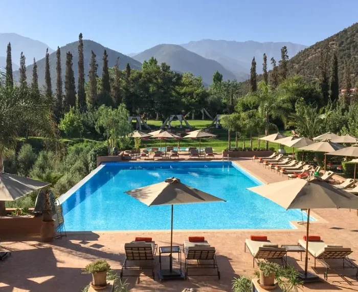 A serene pool area featuring lounge chairs and umbrellas, ideal for relaxation during luxury private tours in Morocco.