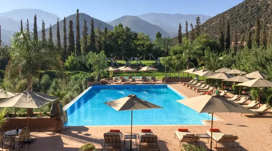 A serene pool area featuring lounge chairs and umbrellas, ideal for relaxation during luxury private tours in Morocco.