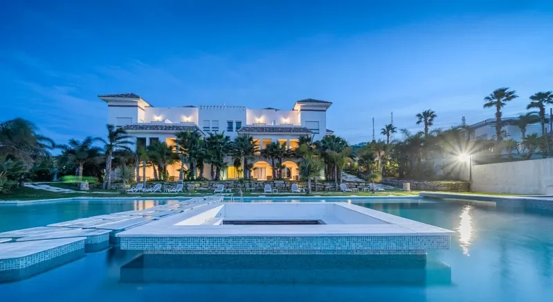 A luxury villa with a pool at dusk, showcasing the elegance of a premium Morocco tour experience.