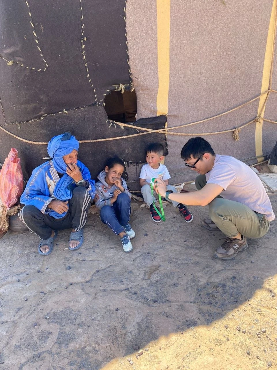 Meeting a Moroccan nomadic family outside their traditional tent in the desert
