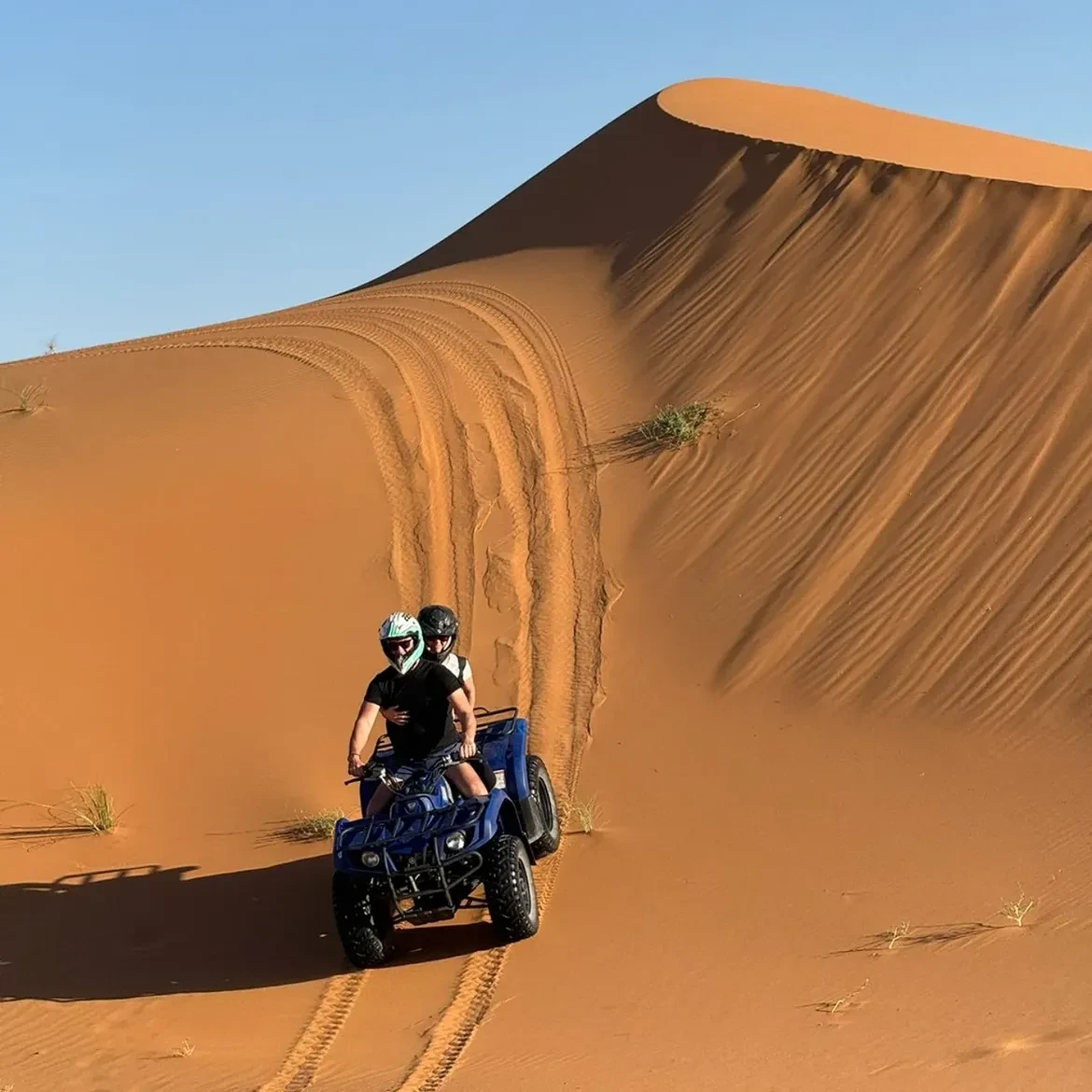 Quad tracks curving across sand dunes after a Merzouga desert excursion
