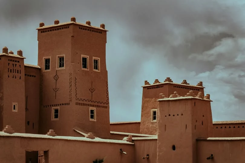 The towers of Taourirt Kasbah in Ouarzazate rising above the earthen walls
