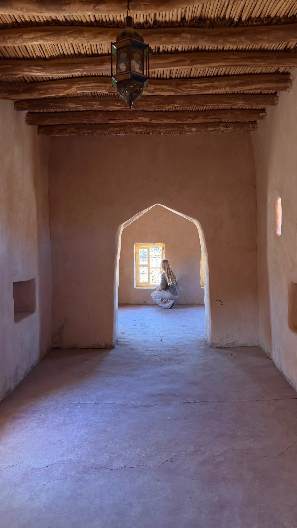 A visitor exploring a decorated room inside Taourirt Kasbah in Ouarzazate